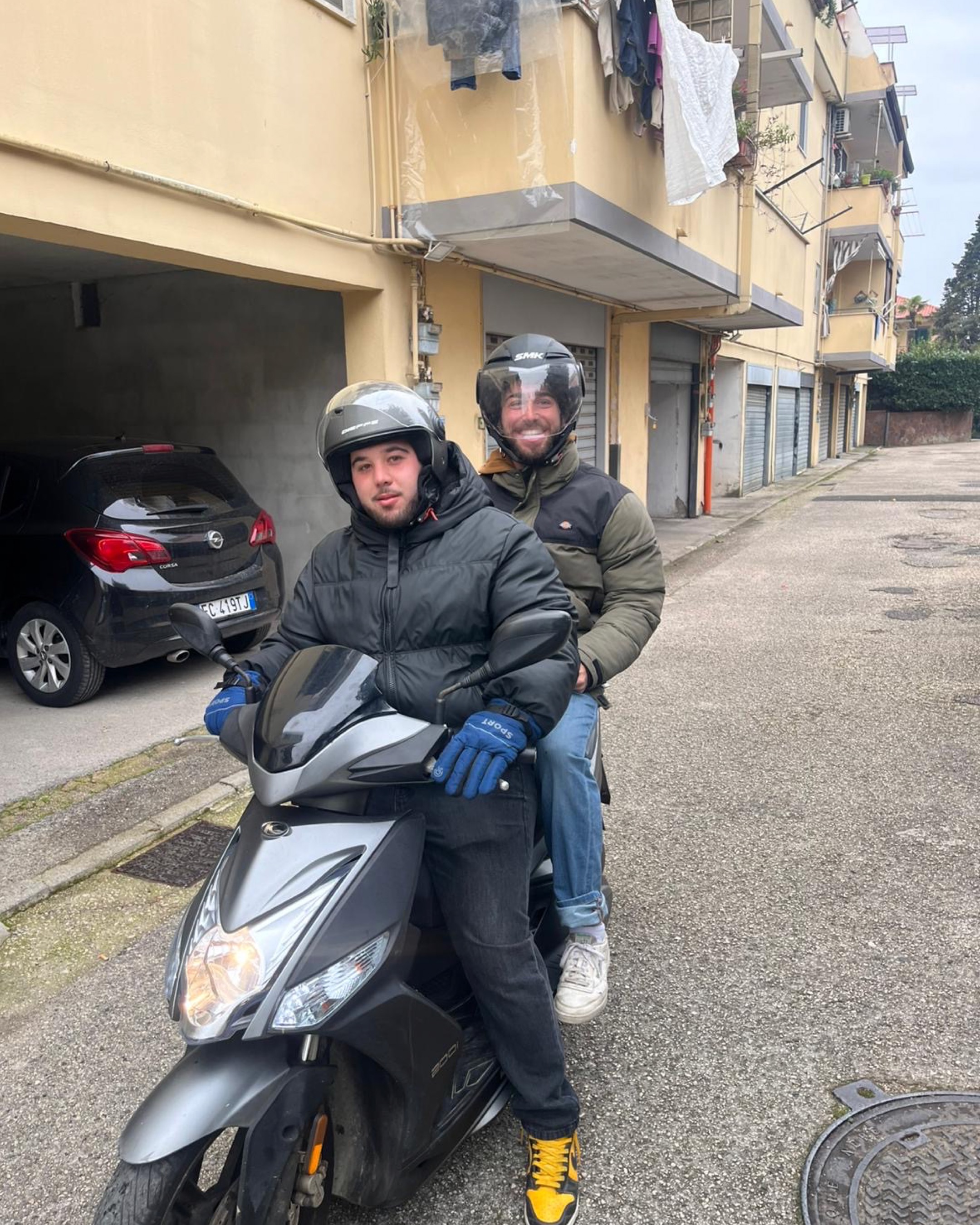 Santo and a friend on a scooter in an Italian neighborhood